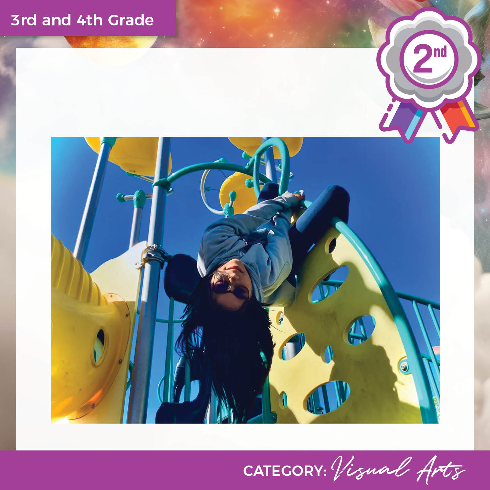 photograph of young person on playground equipment with clear skies