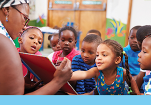 Teacher reading story book to engaged group of preschool students