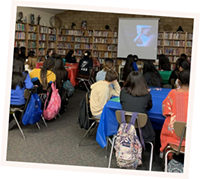 Group of young women watching film in school library