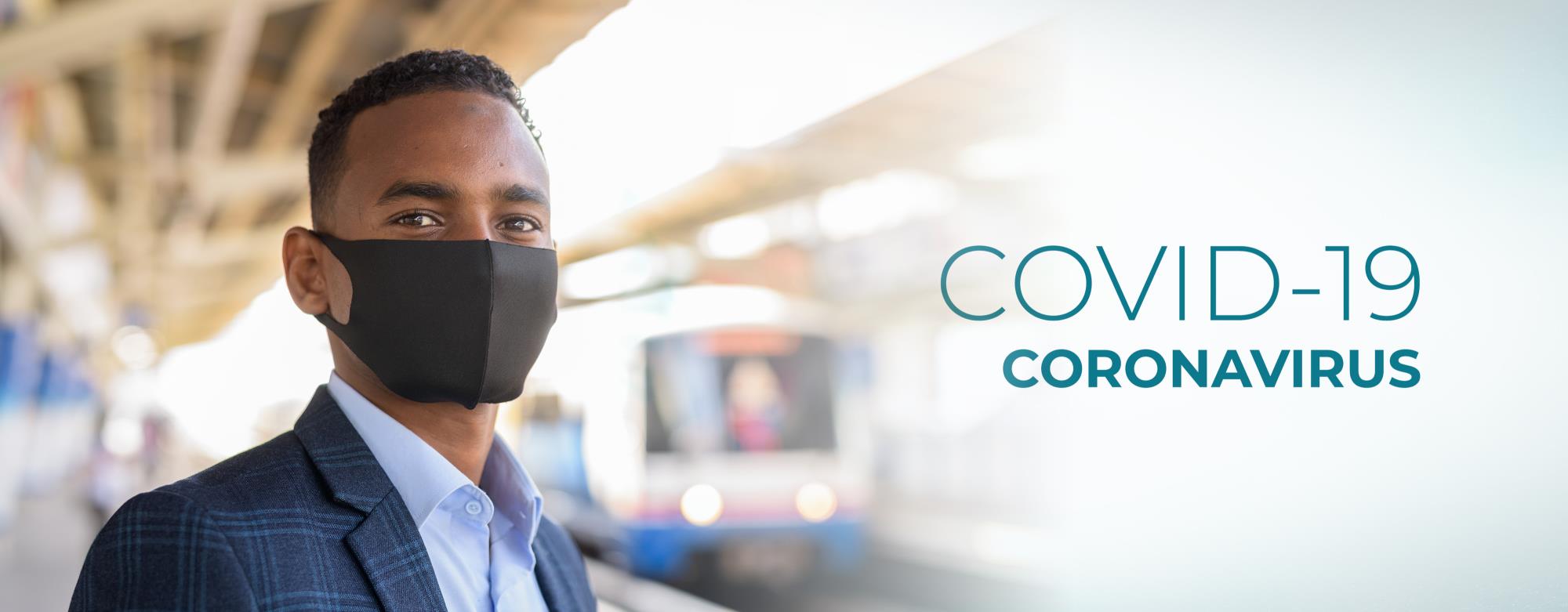 COVID-19 Coronavirus. Man wearing mask waiting for train