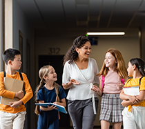 Friendly teacher walking and talking with junior high students