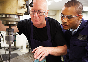 CTE teacher with student working industrial drill