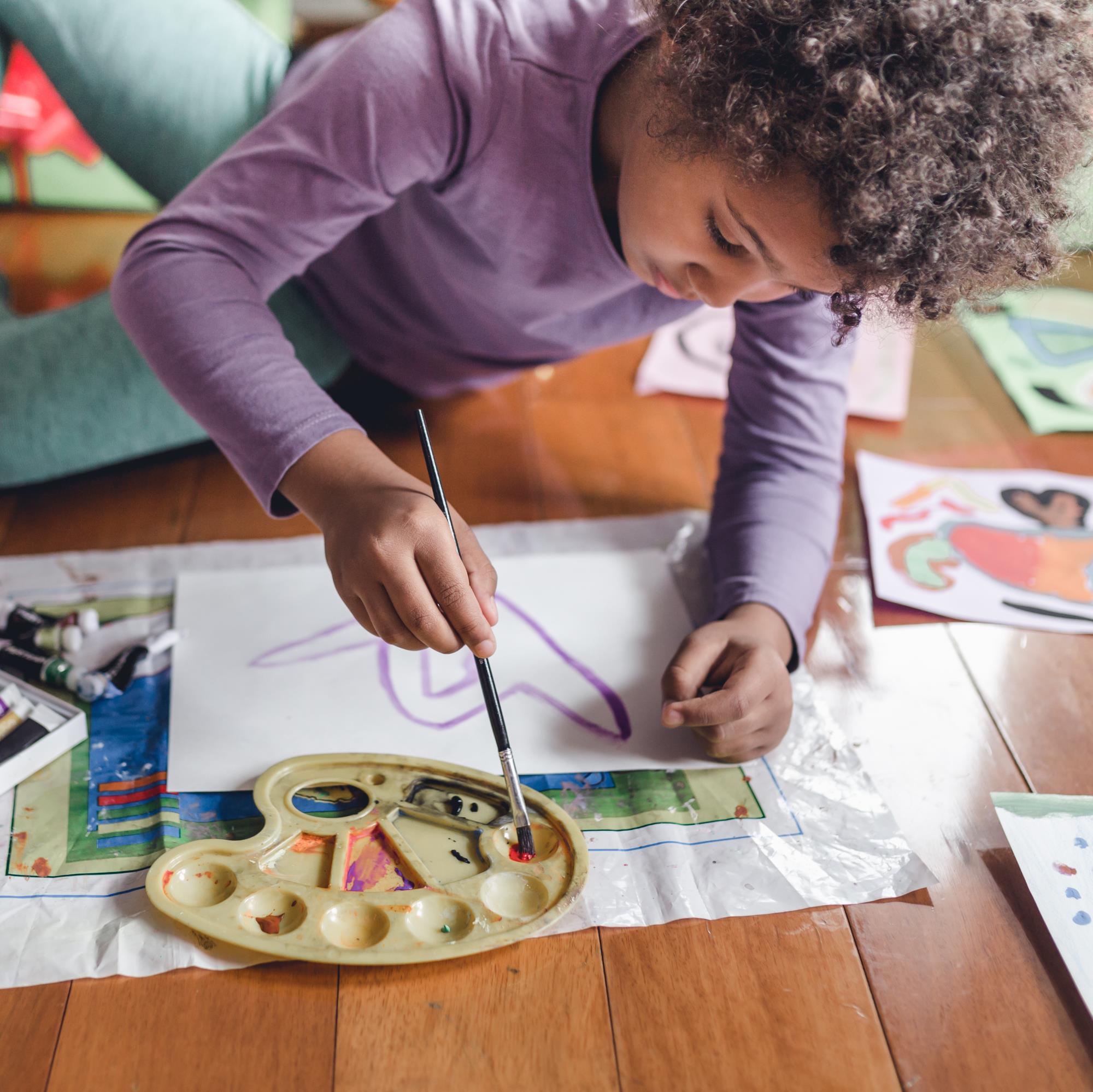 Child painting on floor