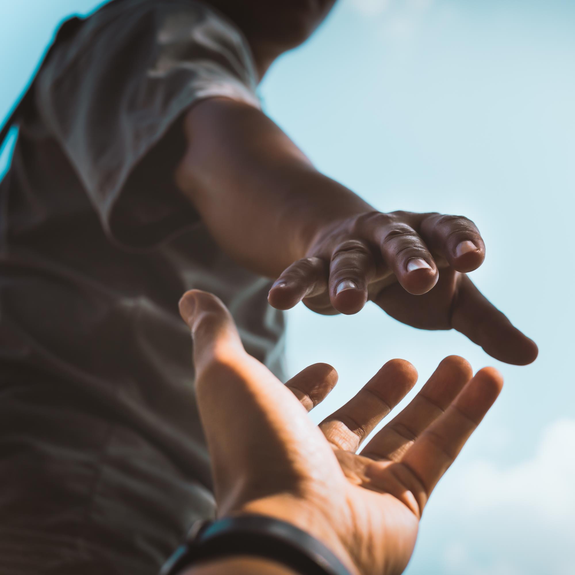 a person reaching out for another person