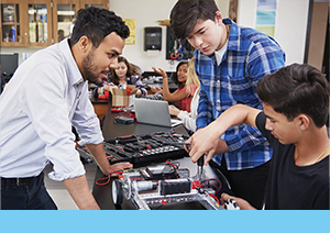 Instructor supervising two students with technical hands on activity