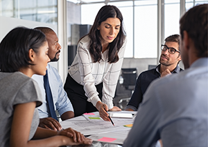 manager sharing documents with team at conference table