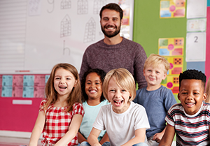 Male teacher with preschool children in classroom